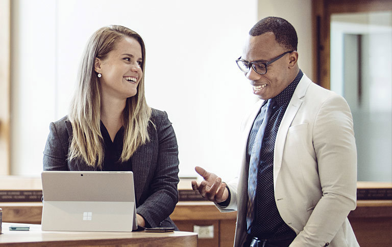 Two MSc students conversing over something on a laptop screen