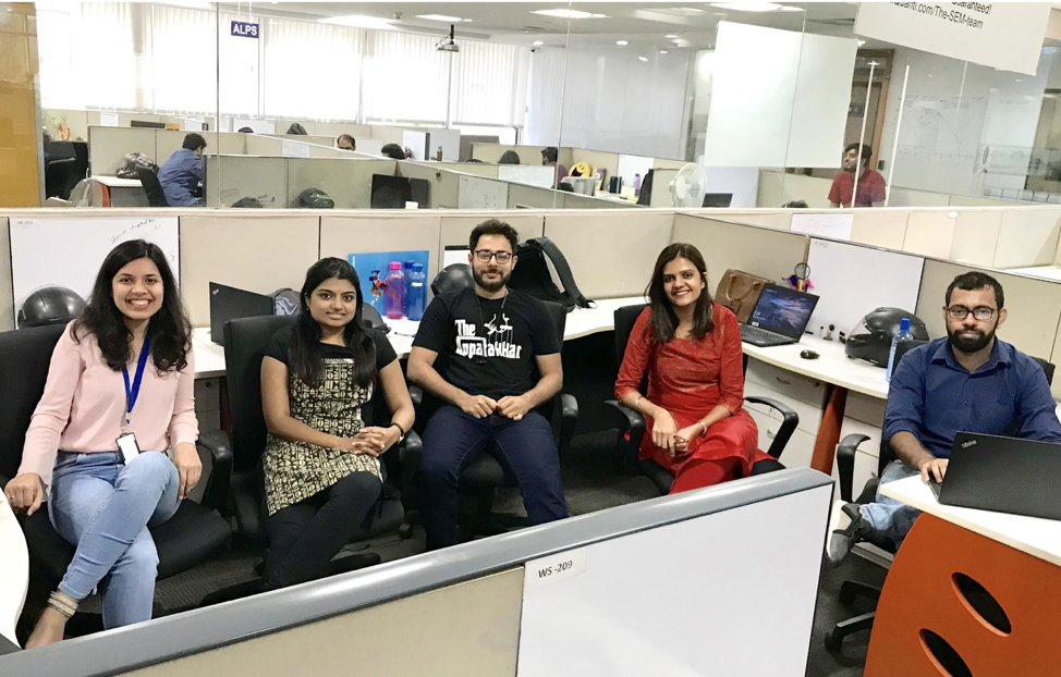 A group of employees in an office, smiling for the camera