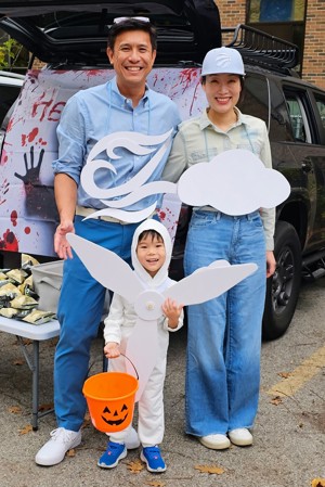 Father, mother, and young son pose for photos on Halloween dressed in costumes