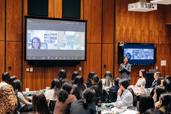 Yasmene McDaniel (onscreen) speaking to the group