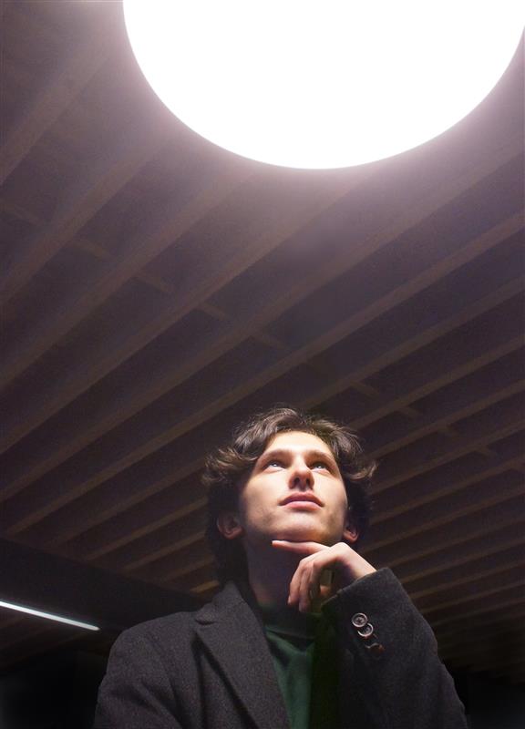 Ben looking like he is thinking under moody lighting in the Ivey building